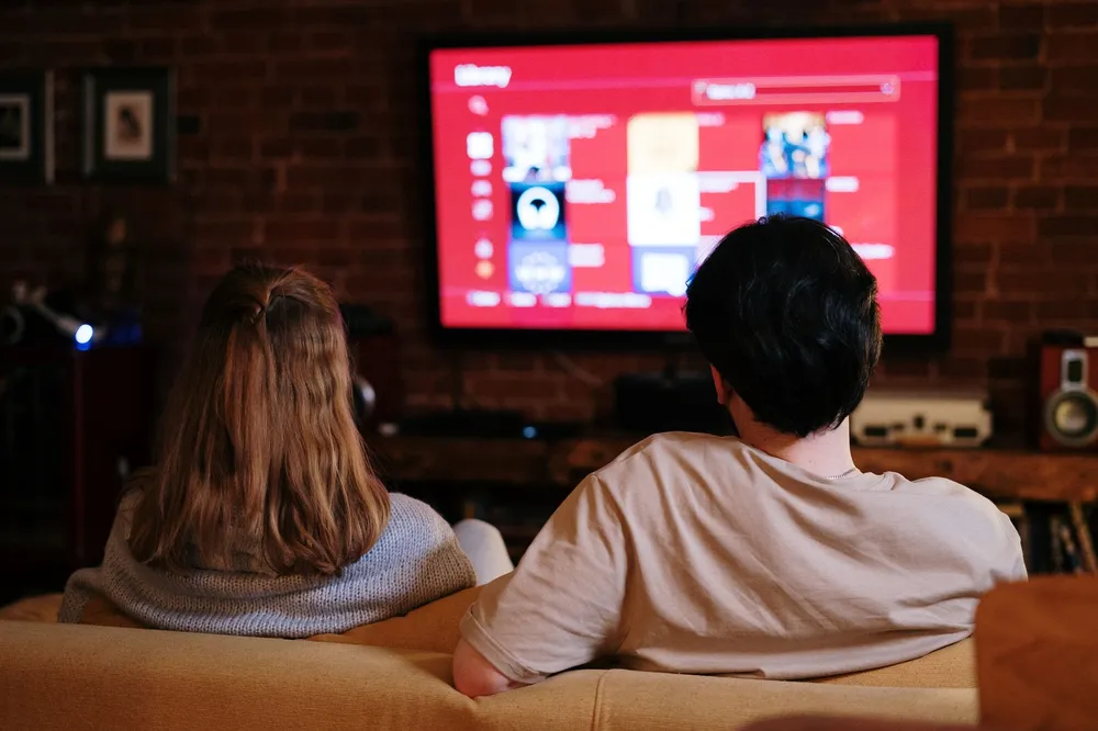 Salon home cinéma dans la pénombre avec téléviseur et barre de son