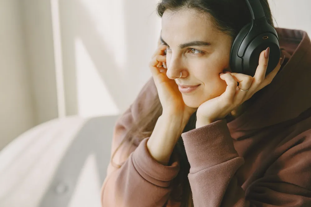 Personne écoutant de la musique au casque à réduction de bruit, yeux fermés