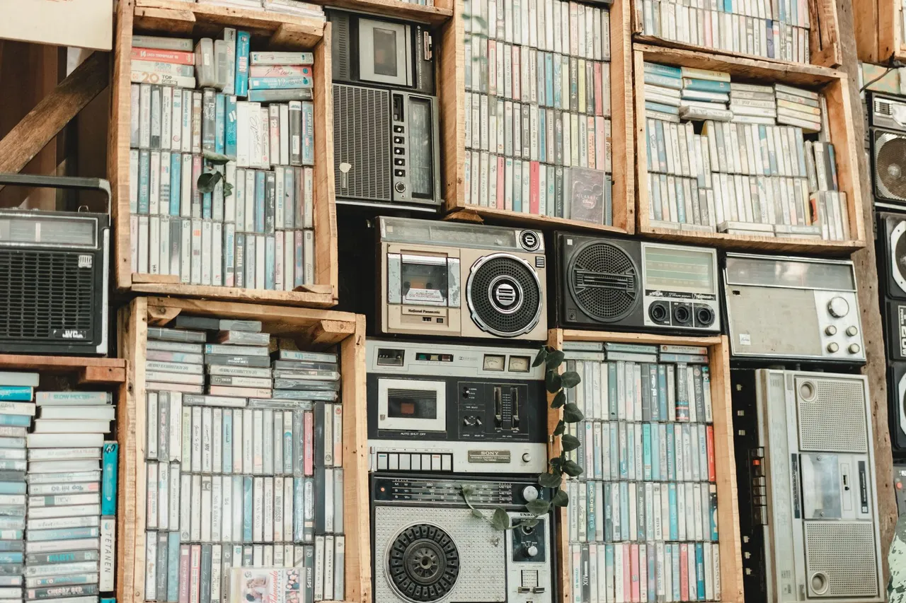 Mur de vieux postes de radio et de radiocassettes empilés sur des étagères de brocante