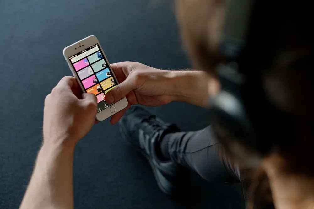 Smartphone affichant une application de musique en streaming avec un casque